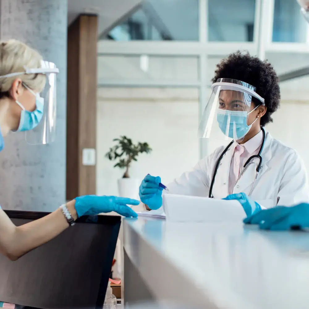 A doctor and nurse coordinating at a hospital reception desk
